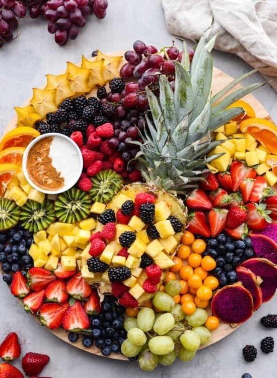 Colorful fruit charcuterie board with pineapple.