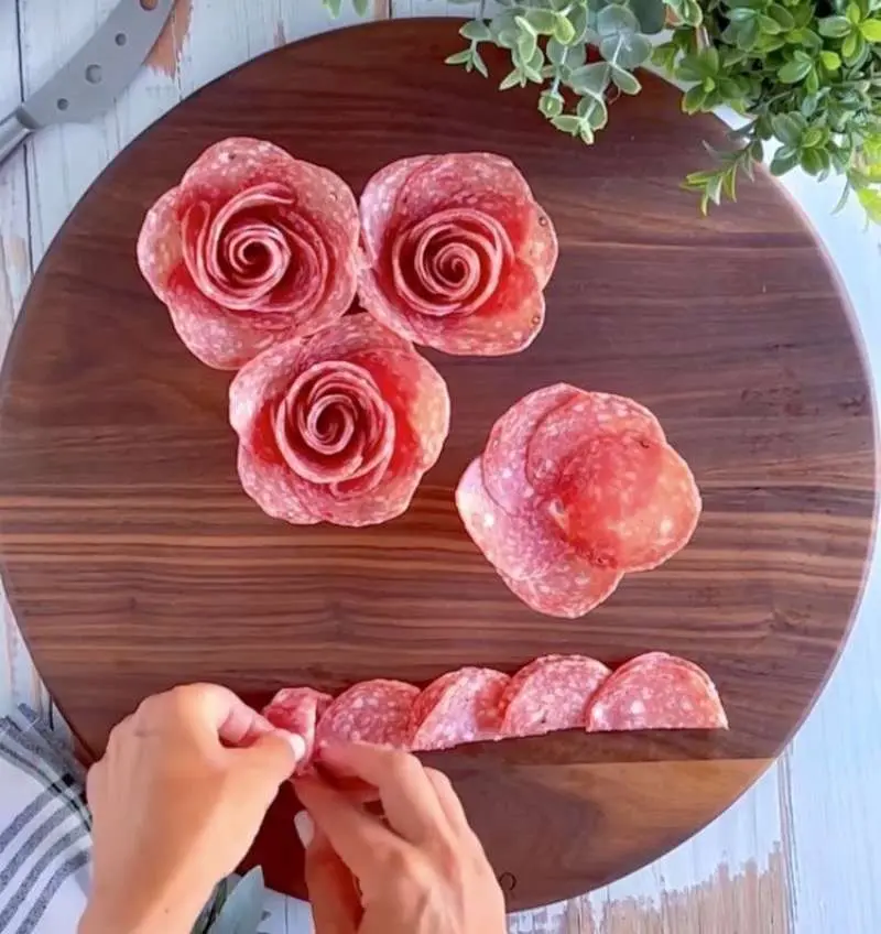 Building a salami rose charcuterie board.