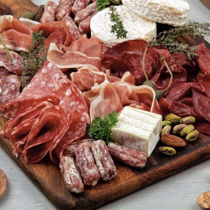 Heart shaped charcuterie board with expensive meat.