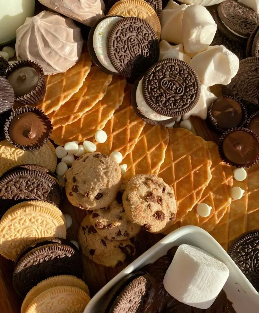 Oreos, marshmallows, and cookies on a board.