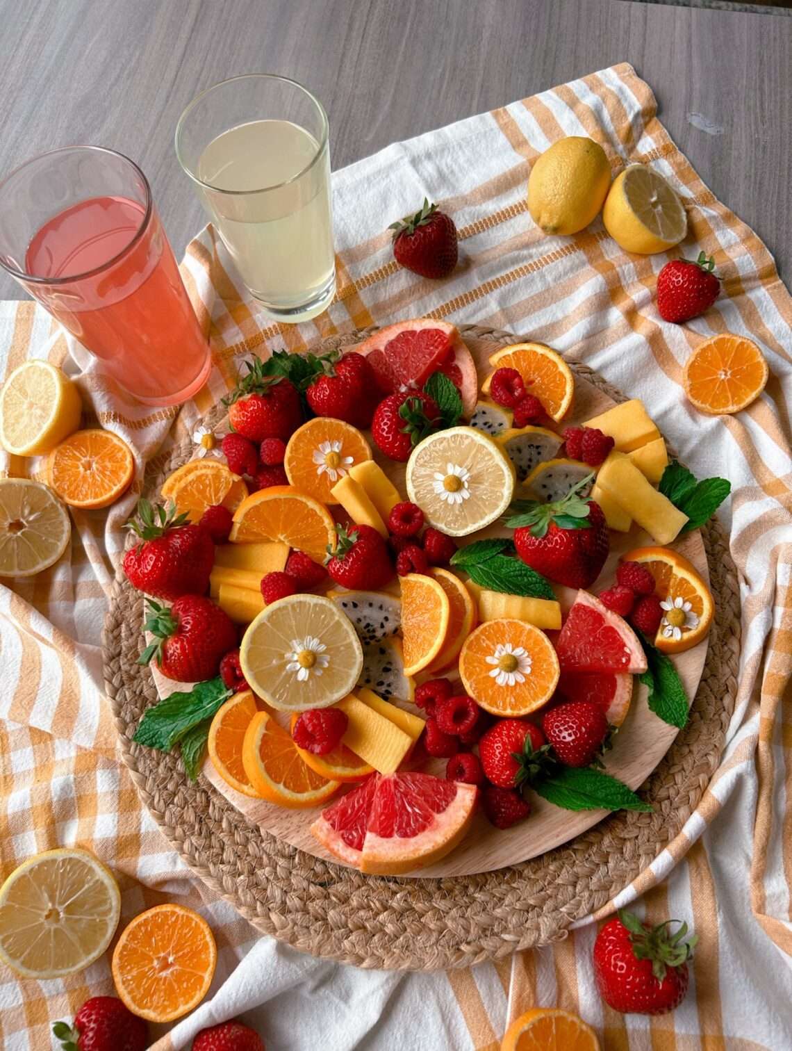 An overview of the lemonade inspired fruit board with 2 cups of lemonade next to it.
