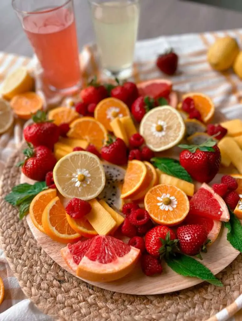 A lemonade-inspired fruit board with 2 cups of lemonade in the background.